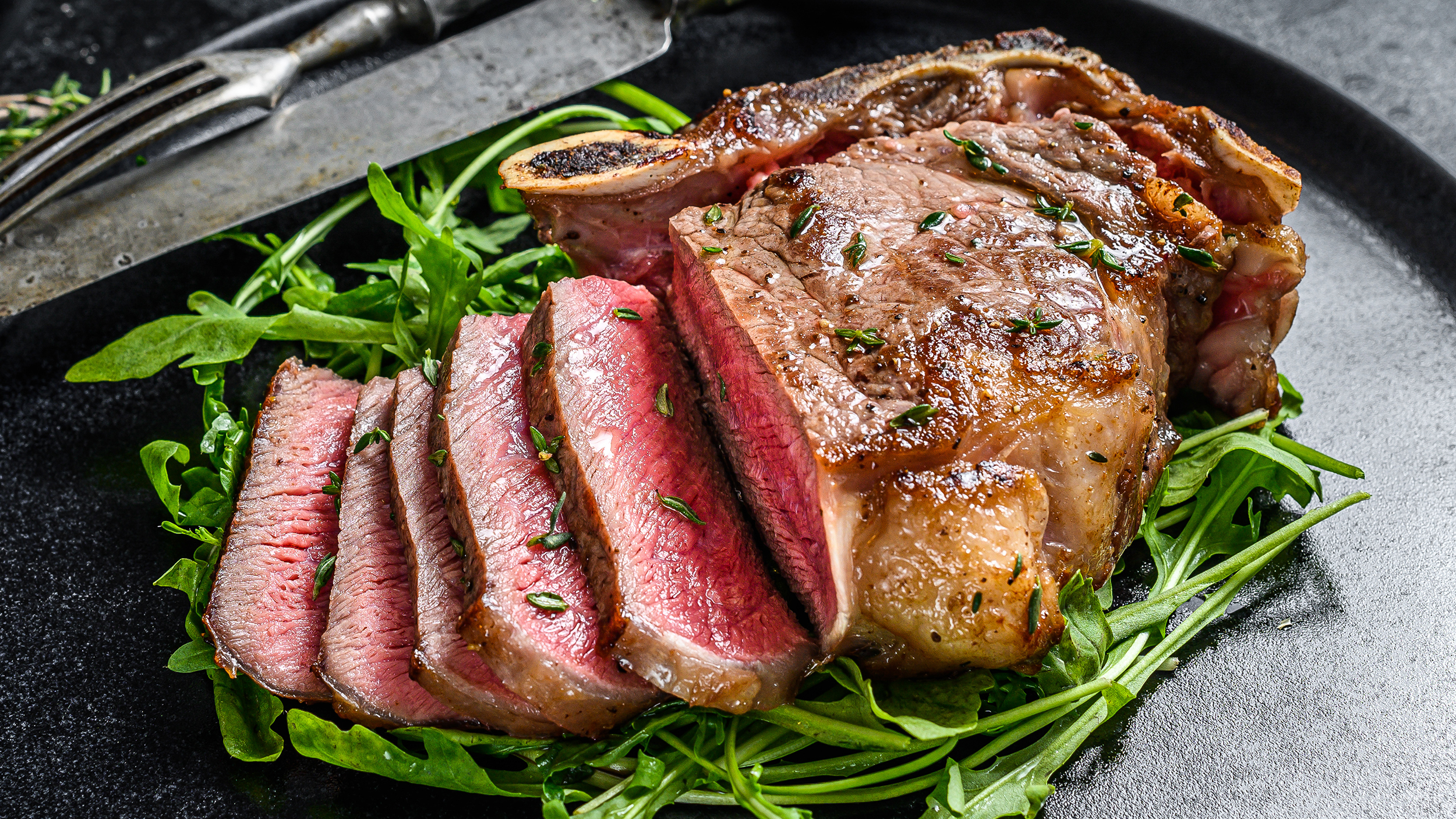 Rare sliced grilled club beef meat steak. Black background. Top